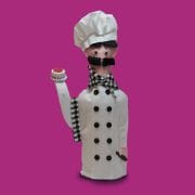 A chef doll with a hat and a white coat.