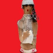 A doll with a white hat and necklace on it's head.